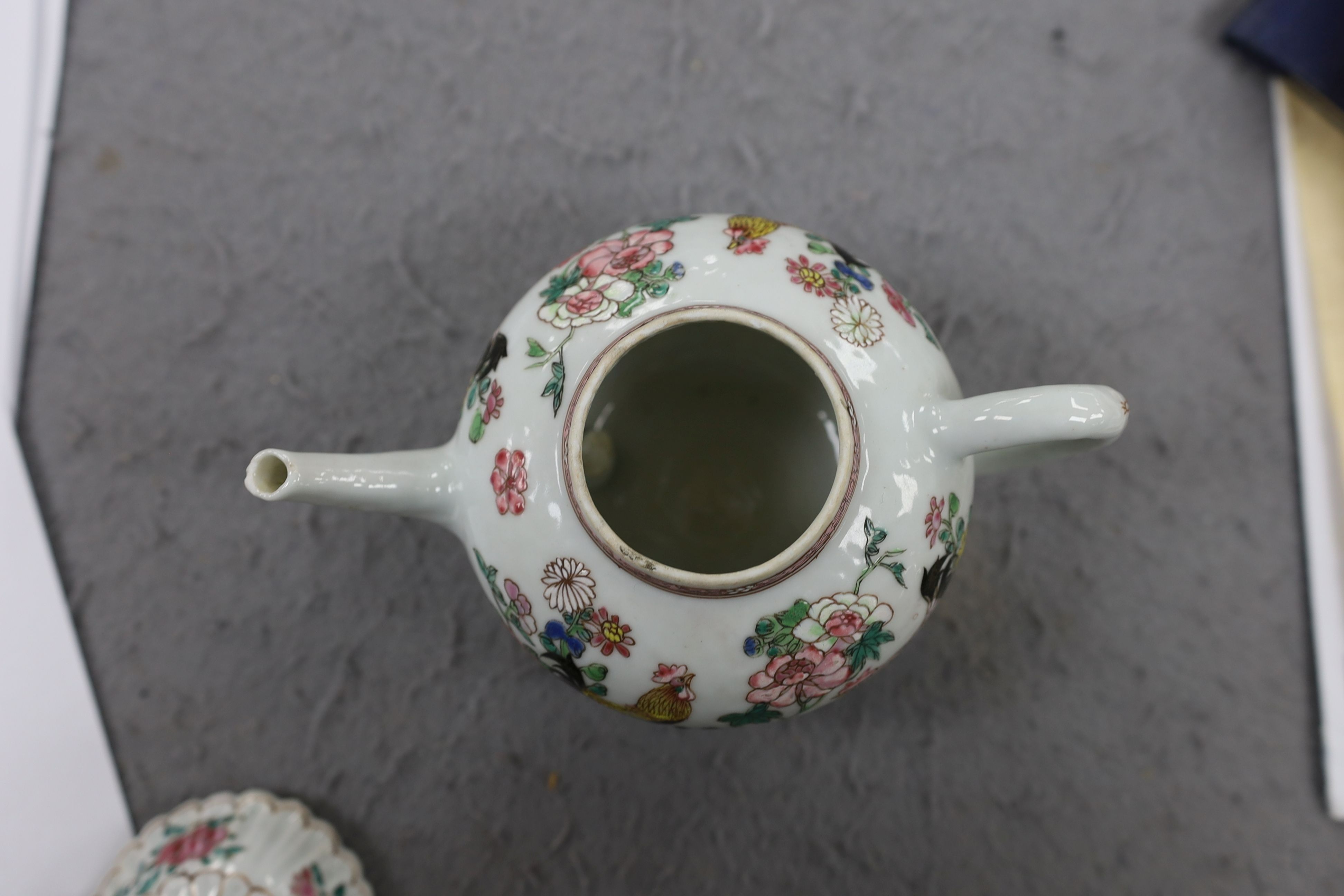 A Chinese famille rose chrysanthemum moulded teapot, early Qianlong period, painted with a cockerel amongst flowers, on a cage work base, 10 cms high